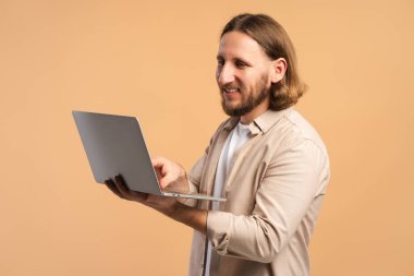 Bilgisayarla uzaktan çalışan gülümseyen adam, modern teknolojinin ve serbest yaşam tarzının tadını çıkarıyor.