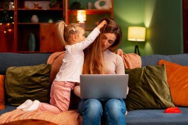 Çalışan anne, çocuğun oturma odasında ilgiye ve laptopa ihtiyacı olduğu için bunalmış hissediyor.