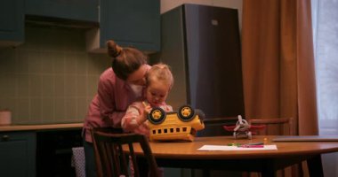 Bir anne ve küçük kızıyla mutfakta oynarken mutlu bir aile anı.