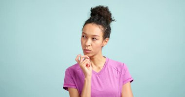 Düşünceli genç kadın derin düşünüyor ve mavi arka planda bir çözüm buluyor.