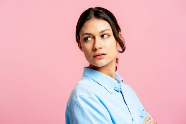 Genç bir kadın geçmişe bakıyor ve pembe bir arka planda şüphe, endişe ve belirsizlik gösteriyor.