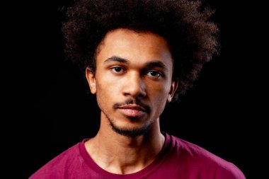 Siyah arka planda afro saçlı bir adam. İfade kararlılığı
