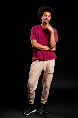 Genç siyahi adam düşünür, düşünür ya da çözüm bulur, elleri çenesinde, stüdyo çekimi