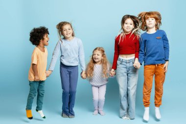 Çeşitli çocuklar zıplıyor ve gülüyor, arkadaşlığı ve çocukluğu canlı bir arka planda kutluyorlar.