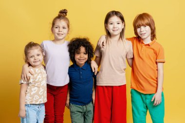 Kollarını omuzlarına almış gülümseyen çeşitli çocuklardan oluşan bir grup, beraberlik ve birlikteliği destekliyor.