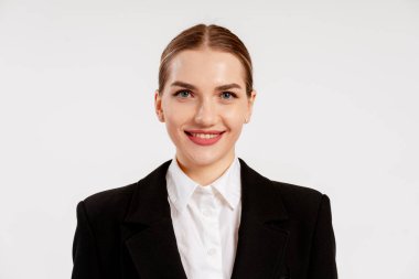 Zarif iş kadını gülümsüyor, kendine güveni ve profesyonelliği beyaz arka planda yayıyor.