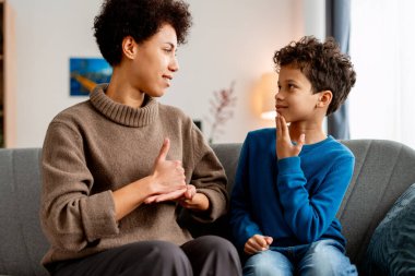 Anne ve oğul iletişim ve anlayış için işaret dilini kullanarak etkileşim halindeler.