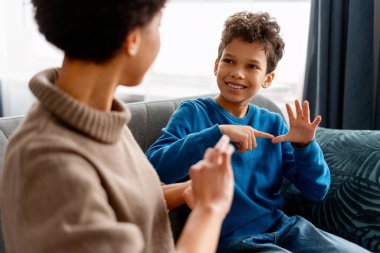 Erkek ve kadın işaret dili kullanarak iletişim kuruyor, dahil edilmeyi ve eğitimi teşvik ediyor.