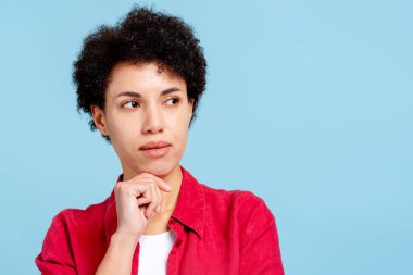 Düşünceli kadın başka yere bakıyor, eli çenesinde seçenekleri düşünüyor.