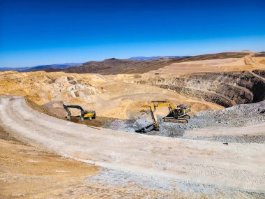Açık maden ocağında çalışan inşaat makineleri
