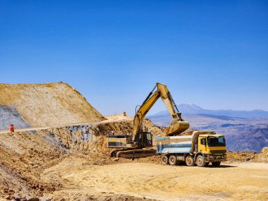 Açık maden ocağında çalışan inşaat makineleri
