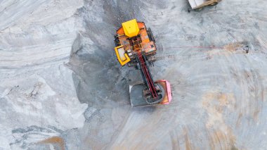 Ağır madencilik makineleri açık bir maden ocağında mineraller çıkarıyor.