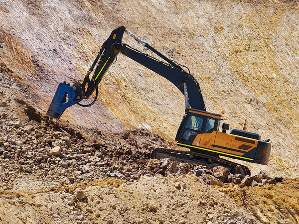 Строительная техника в процессе профилирования заполняющей платформы в карьере