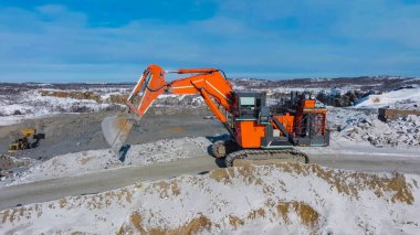 Dev maden kazıcısı açık bir maden ocağında kaya malzemesi çıkarma sürecinde.