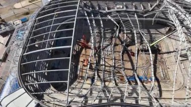 Çökmüş metal yapısı olan ve yapısal denetimlerden geçen bir stadyumun havadan görünüşü