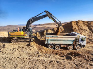 Kil toprağı yükleme sürecinde inşaat makineleri