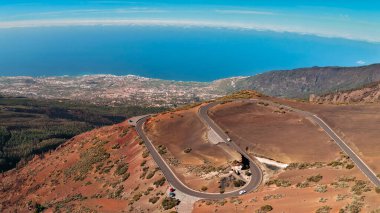 Kurak dağlarda geniş yarıçaplı gelişim eğrileri olan bir yolun havadan görünüşü