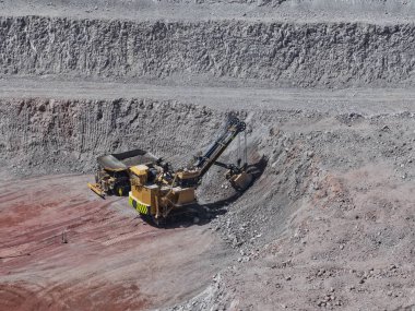 Bakır cevherlerini açık maden ocağından çıkarıp yükleme sürecinde devasa bir elektrikli kürek.