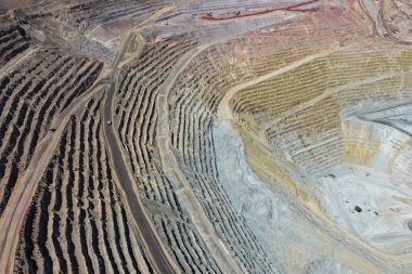 Güneşli bir günde bir sürü tezgahı ve maden yolu olan büyük bir açık maden ocağının havadan görünüşü