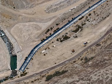 Yeraltı su taşımacılığı için maden kenarlarındaki jeosentetik ve kaya kanallarının havadan görünüşü