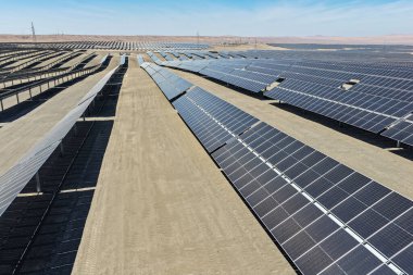 Çölde güneş izleme sistemi olan mekanize fotovoltaik panellerin panoramik görüntüsü