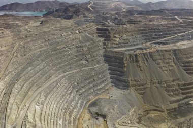 Açık maden tezgahlarının panoramik hava görüntüsü ve birden fazla çalışan yüz.