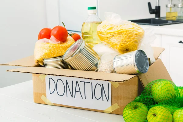 Öppen donationslåda med mat i köket. Hjälp för människor. Begreppet välgörenhet — Stockfoto