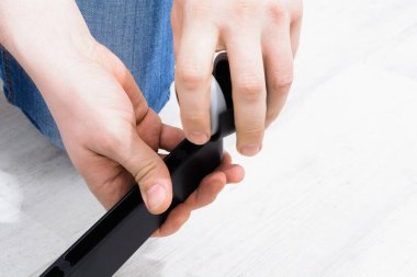 Caucasian man hands screw the wheel to the chair leg