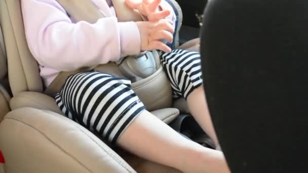 Pequeño bebé sentado en un asiento de coche especial con cinturones de seguridad — Vídeo de stock