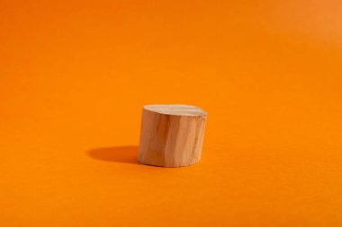 Turuncu üzerinde ahşap yuvarlak podyumun boş gösterisi. Geometrik biçimli sahne