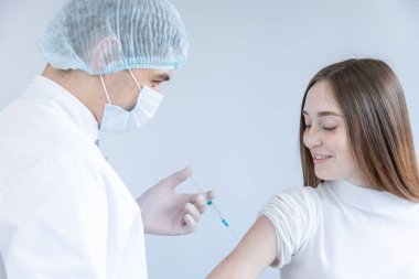 Bir hastanın omzunda aşı yapan bir doktora yaklaş.
