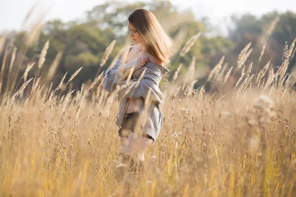 Bellezza ragazza con lungo rosso soffiare capelli all'aperto . Foto Stock