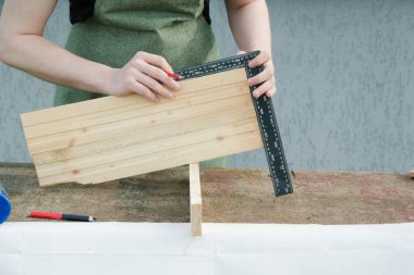 Marangoz ahşap tabakla çalışıyor. Marangoz ahşap kalasla çalışıyor. Genç adam evinin yakınında çalışıyor.. 