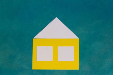 Renkli arka planda geometrik kağıt figürlerinden yapılmış ev.