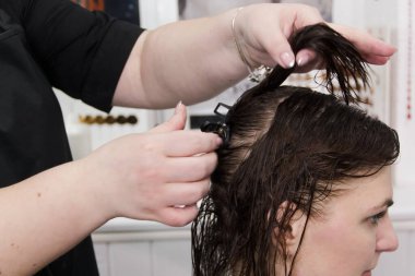 Küçük kuaförde müşterisiyle çalışan kuaför. Kuaför ve müşteri saç tıraşı seçiyor..