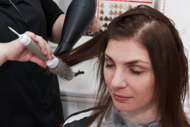 Küçük kuaförde müşterisiyle çalışan kuaför. Kuaför ve müşteri saç tıraşı seçiyor..