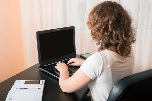 Bir dizüstü bilgisayar üzerinde çalışan bir kadın 