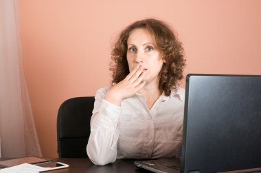 Ofiste oturan ve dizüstü bilgisayar kullanarak sürpriz/şok kadın