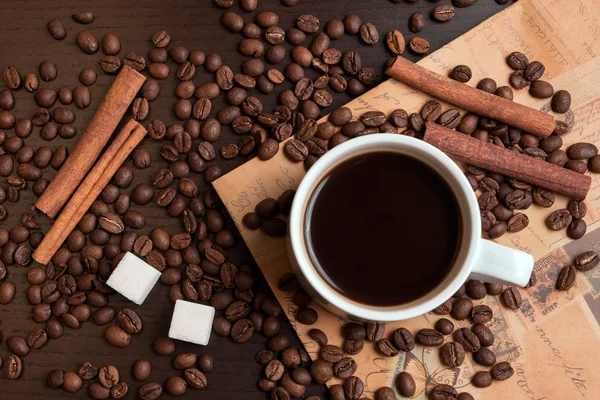 Xícara de café, grãos de café, cubos de açúcar e canela — Fotografia de Stock