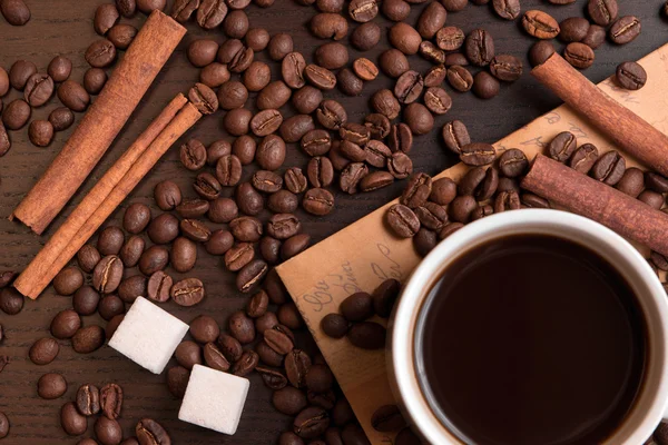Чашка кофе, кофейные зёрна, кубики сахара и корица — стоковое фото
