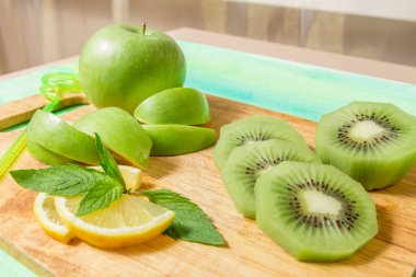 Elma, kivi, limon ve nane ahşap tahta üzerinde