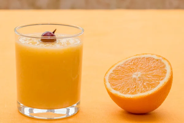 Orange smoothie with gooseberry on orange background