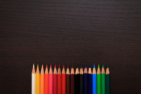 Színes ceruzák hely sötét háttér szöveg — Stock Fotó