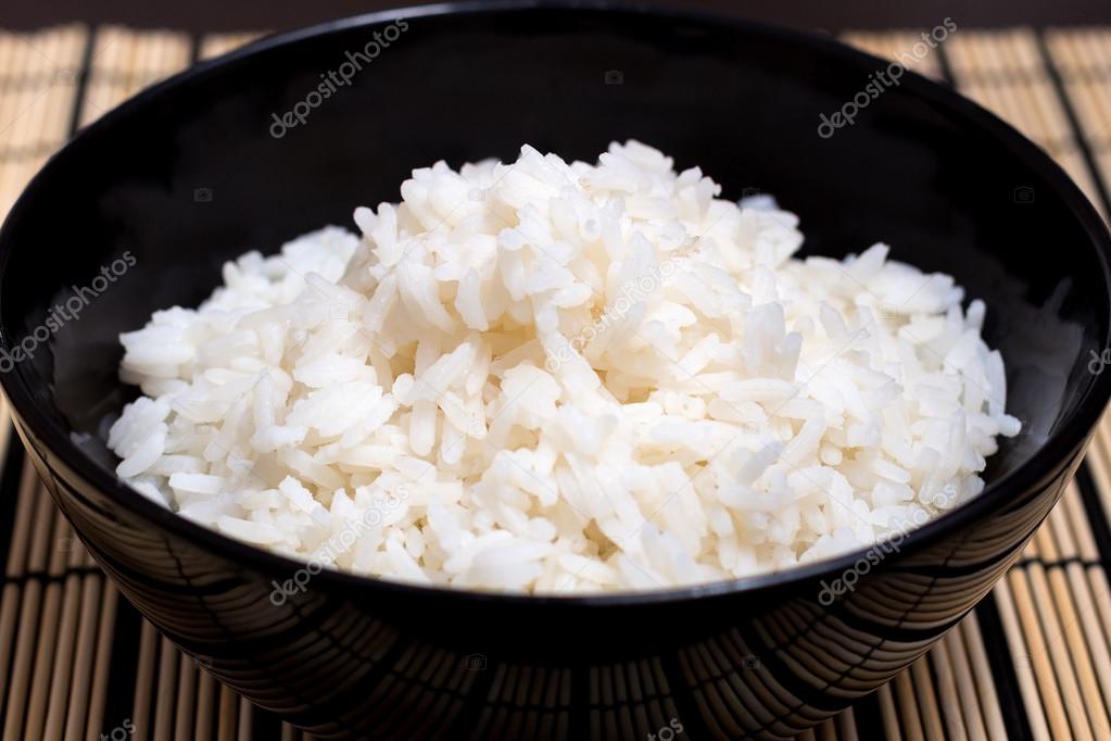Cooked steamed rice in a black plate