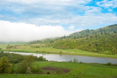 Nehrin eteklerinde nehir. Dev bir bulut. Carpathians, Ukrayna.