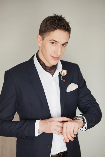 Genç adam ayakta bakarak saatler ile kamera