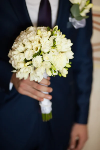 Bruidegom houden het boeket van bloemen Stockfoto