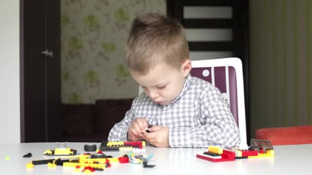 Rapaz sério a tentar separar tijolos de kit de construção infantil — Vídeo de Stock