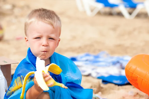 Petit beau garçon avec banane sur le sable — Photo