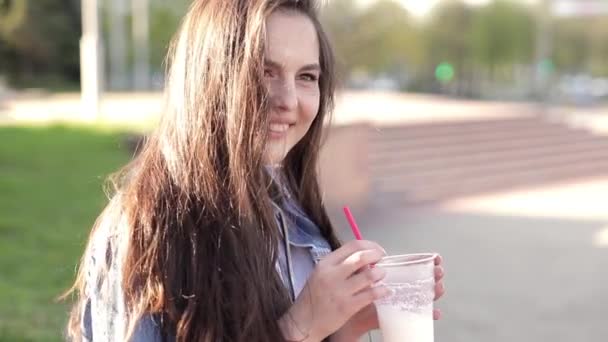 Cocktail trinken, lächeln und posieren, an der Wand sitzen — Stockvideo